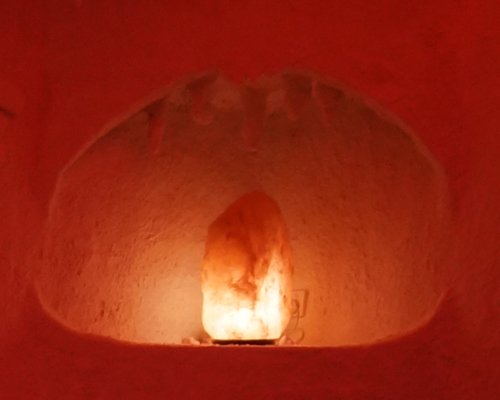 Salt cave seating area with comfortable loungers and salt-covered walls
